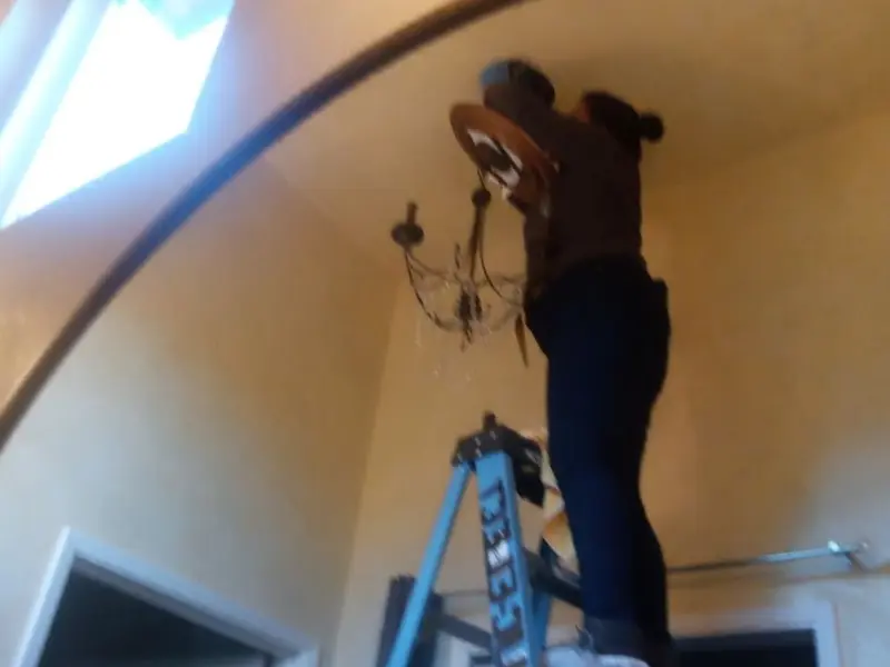 Electrician installing a chandelier in a Camarillo residence